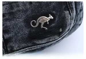 Macro shot of silver kangaroo logo on dark gray washed denim texture fabric