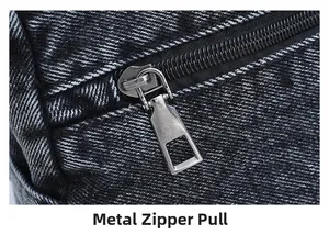 Close-up of durable silver metal zipper on black washed denim fabric with neat stitching