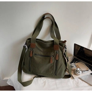 Vue détaillée du sac cabas en velours côtelé vert foncé avec ordinateur et casque