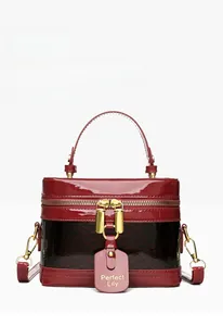 Detail of red patent leather and snake skin texture bag with gold hardware and logo tag
