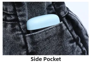 Detail view of the side pocket on a black washed denim crossbody bag for storage