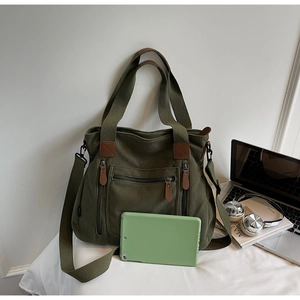 Détail du sac en velours côtelé vert armée avec trois poches et tirettes en cuir pour la taille