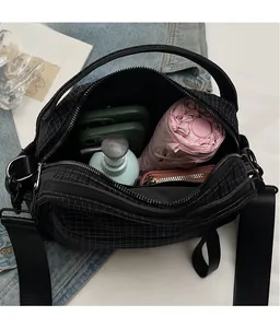 Top view of the spacious inner compartment of the black checkered nylon crossbody bag