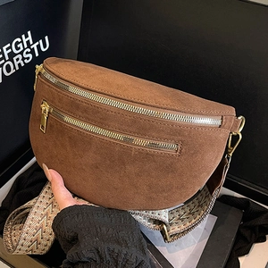 Brown suede crossbody saddle bag with wide geometric strap and double silver zippers