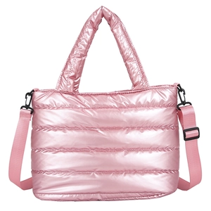 Sac à main matelassé rose métallisé avec bandoulière réglable et poignées sur fond blanc