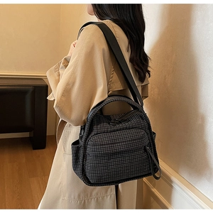 Detail of grid patterned nylon backpack showing side pocket and adjustable strap