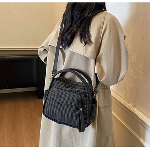 Detail of dark grey nylon crossbody bag with zipper pocket and adjustable shoulder strap