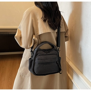 Macro detail of the checkered nylon crossbody bag with front pocket and durable handle