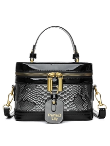 Detail view of box-shaped handbag with black patent leather and grey snakeskin texture