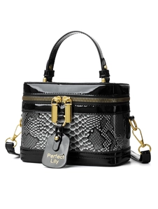 Detail of the high-gloss patent leather and gray snake pattern texture on the box handbag
