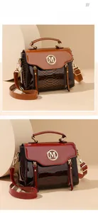 Detail of snake skin texture and metal M logo on brown and red leather handbags