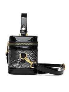 Detail of snake print box bag featuring gold zipper hardware and sleek black patent trim