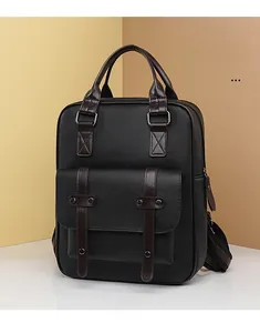 Détail du sac à dos en cuir noir grainé avec poignée marron et boucle métallique