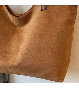 Détail d'un cabas en daim marron caramel montrant la texture mate et les coutures