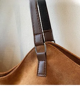 Gros plan du sac cabas en daim caramel avec ferrures argentées et coutures