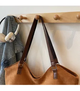 Détail du sac cabas en suède avec bandoulière robuste et boucle métallique argentée