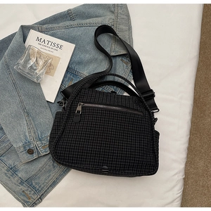 Close-up of lightweight black grid nylon crossbody bag with front zipper and dual straps