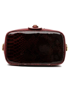Detailed base view of burgundy snake-pattern leather handbag with fine gold buckles