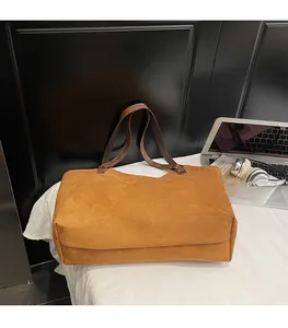 Détail du grand sac cabas en daim marron avec des anses en cuir robustes pour le quotidien