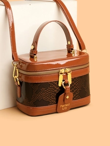 Detail of vintage box handbag featuring brown snakeskin texture and gold hardware