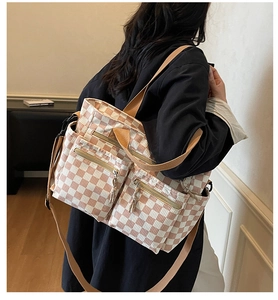 Detail of checkered tote bag with three functional front zipper pockets and canvas straps