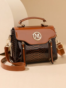 Close-up of brown textured leather crossbody bag with golden M logo and metallic zipper