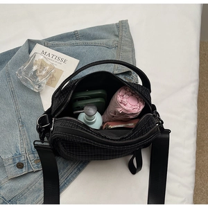 Top view of spacious nylon crossbody bag interior with daily essentials and black strap