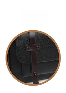 Détail du sac en cuir grainé noir avec une sangle à boucle métallique marron foncé