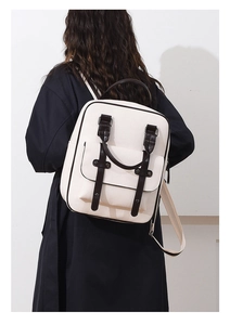 Femme portant un sac à dos en cuir PU crème avec sangles marron et poche à rabat