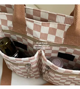 Detail of pink checkerboard corduroy tote featuring double front pockets for easy storage