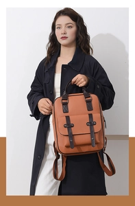 Détails du sac à dos vintage marron avec rivets et sangles porté par un mannequin