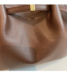 Gros plan sur le cabas en cuir grainé marron foncé avec boucle en métal doré