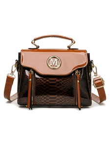 Detail of snake-embossed leather texture and gold M logo on brown crossbody bag