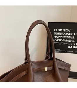 Détail du sac cabas marron en cuir grainé avec une boucle en métal doré élégante