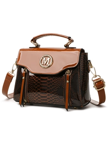 Detailed side view of brown snakeskin embossed handbag with gold metal M logo buckle
