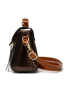 Close-up of snake embossed patent leather surface with gold metal hardware details