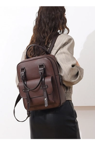 Vue arrière d'un mannequin portant un sac à dos en cuir PU marron foncé au style vintage