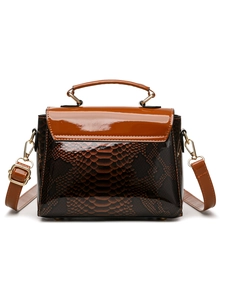 Detail of dark brown snake-print patent leather handbag with gold-tone hardware