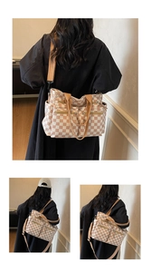 Detailed view of checkered tote bag with multiple functional zippers and adjustable strap