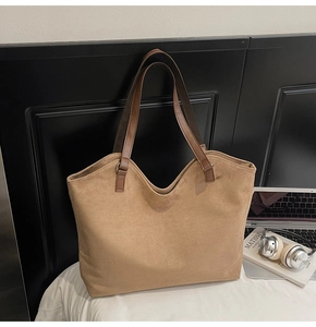 Détail d'un sac cabas en daim marron avec anses en cuir dans un cadre de bureau pro