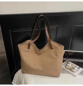 Détail du grand sac cabas en daim marron avec anses en cuir et design spacieux