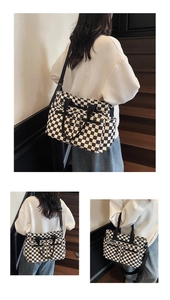 Detail of checkered tote bag with multiple zip pockets and adjustable shoulder strap