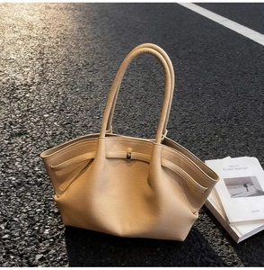 Détail du sac cabas beige minimaliste avec texture grainée et boucle en métal dorée