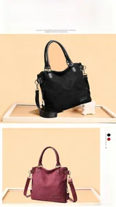 Detail view of large suede tote bags in black and burgundy with premium metal hardware