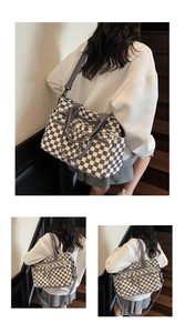 Detail of checkered tote bag with multiple zipper pockets and wide nylon shoulder strap