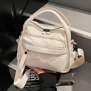 Minimalist beige quilted nylon handbag with adjustable wide strap and wave texture