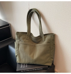 Detail view of army green corduroy tote bag showing large front pockets and ribbed texture