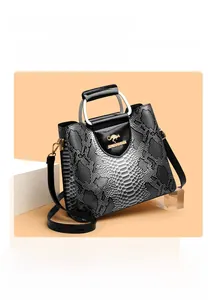 Close-up of snake skin texture handbag with square metal handle and golden kangaroo logo