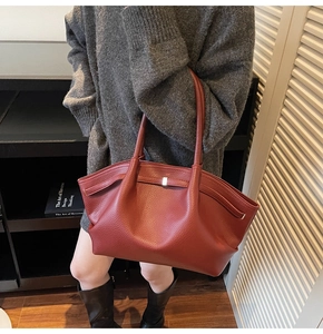 Détail d'un grand cabas en cuir marron rouge avec texture grainée et boucle en métal argenté