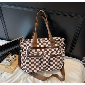 Detail view of checkered tote bag with functional pockets and corduroy texture